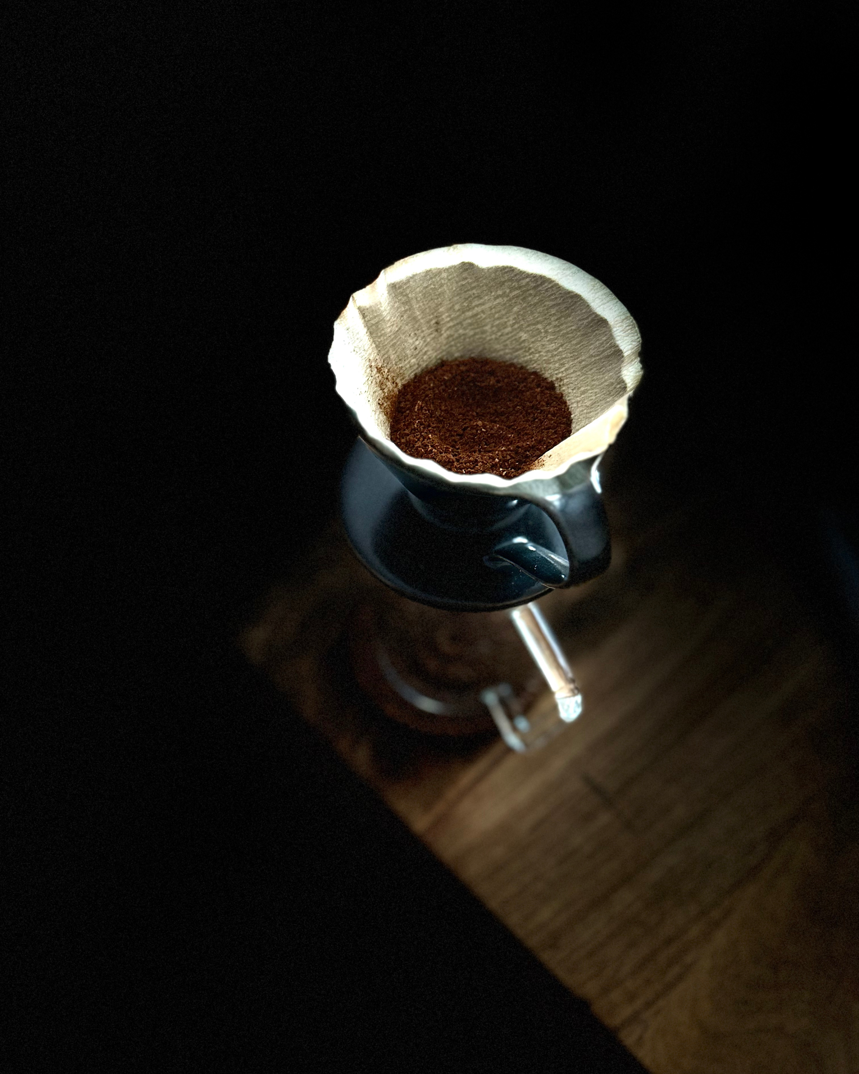 pour over dripper with filter paper and ground coffee kept on a flask