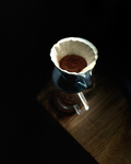 pour over dripper with filter paper and ground coffee kept on a flask